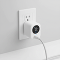 Smart plug with energy monitor plugged into a wall outlet